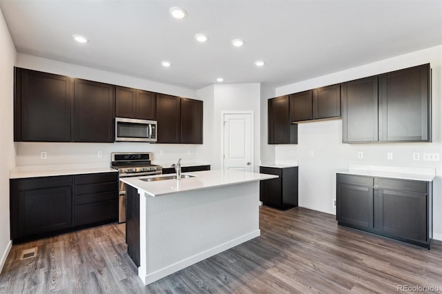 kitchen featuring dark wood-type flooring, dark brown cabinets, stainless steel appliances, and light countertops