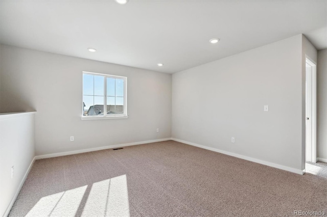 spare room with baseboards, carpet, visible vents, and recessed lighting