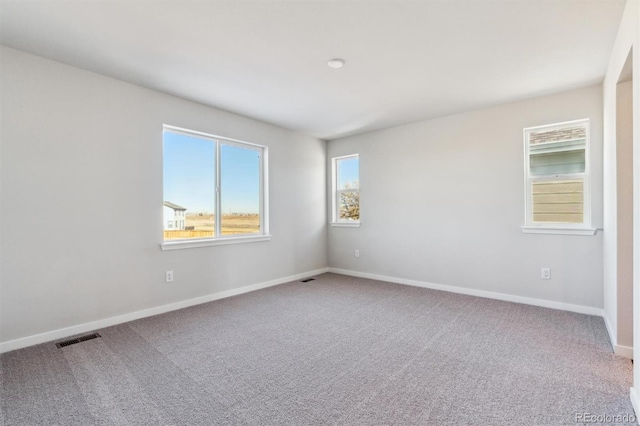 carpeted empty room with baseboards and visible vents