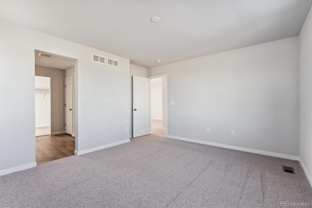 unfurnished bedroom featuring carpet floors, visible vents, and baseboards