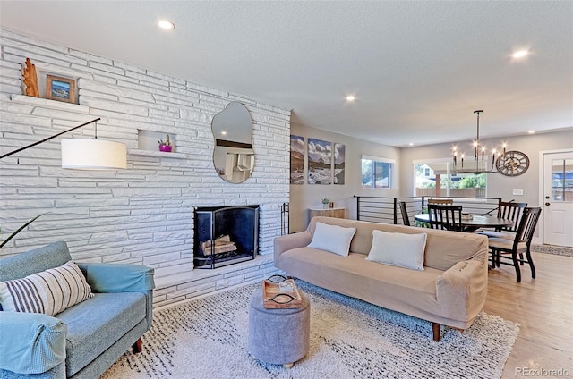 2337 S Franklin St, Denver, CO 80210 - living room featuring a chandelier, recessed lighting, wood finished floors, a large fireplace, and a textured ceiling