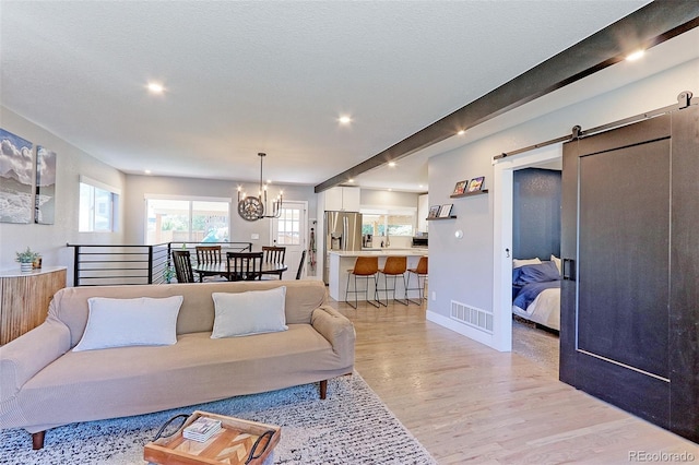 2337 S Franklin St, Denver, CO 80210 - living room with light wood-style floors, a barn door, a chandelier, and recessed lighting