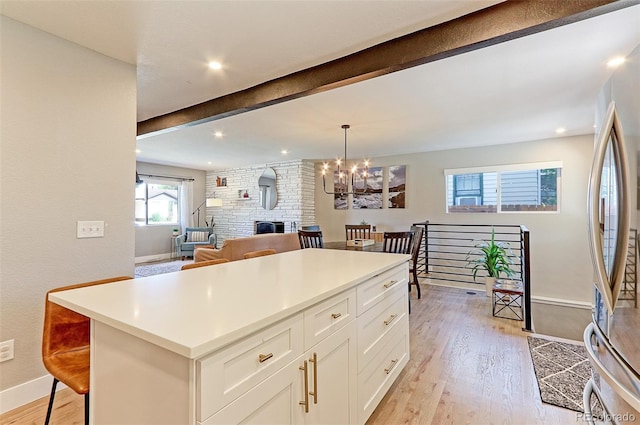 2337 S Franklin St, Denver, CO 80210 - kitchen featuring freestanding refrigerator, light wood-style flooring, a chandelier, beam ceiling, and white cabinetry
