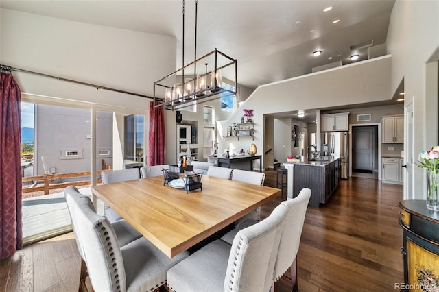 dining room featuring dark wood-type flooring, high vaulted ceiling, and sink