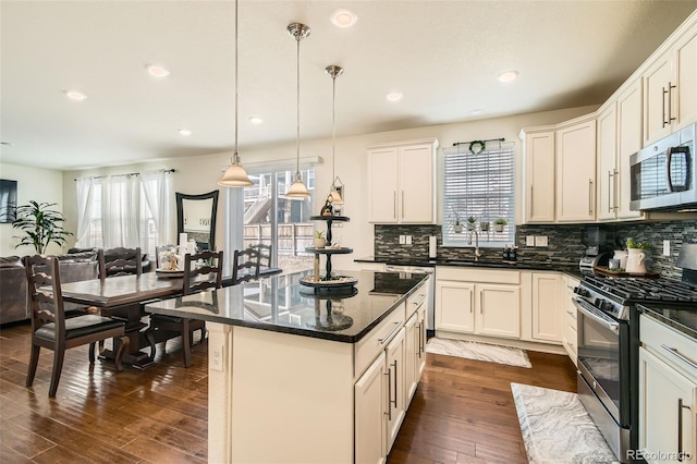 kitchen featuring tasteful backsplash, dark wood-style floors, appliances with stainless steel finishes, open floor plan, and a wealth of natural light