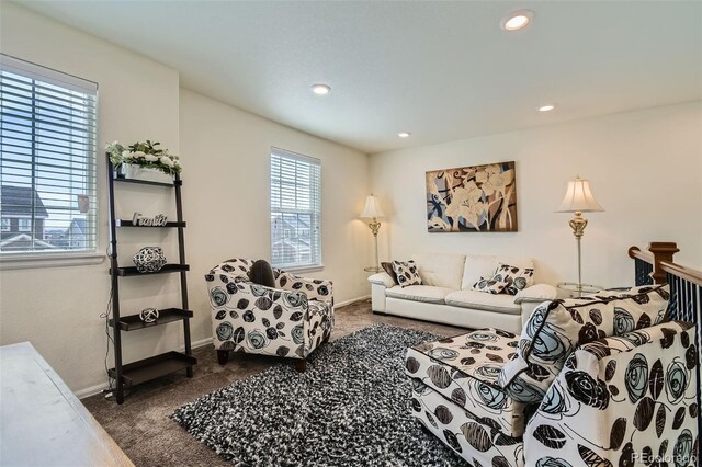 living area with dark colored carpet, baseboards, and recessed lighting