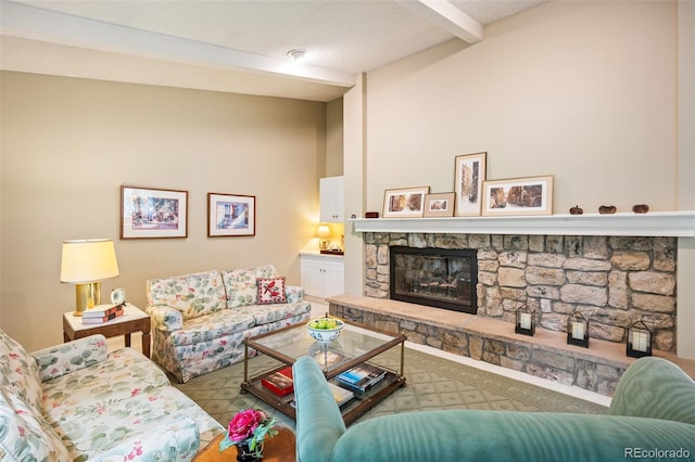 living room with beam ceiling, a fireplace, and a textured ceiling