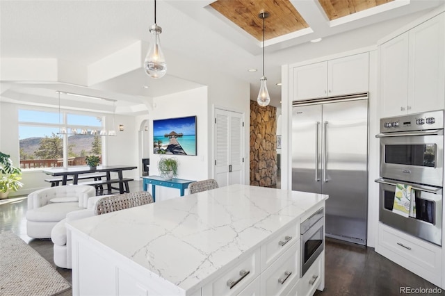 700 Apple Ridge Rd, Lyons, CO 80540 - kitchen with built in appliances, light stone countertops, white cabinets, a kitchen island, and dark wood-style floors