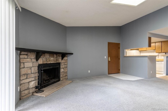 unfurnished living room with carpet flooring and a stone fireplace