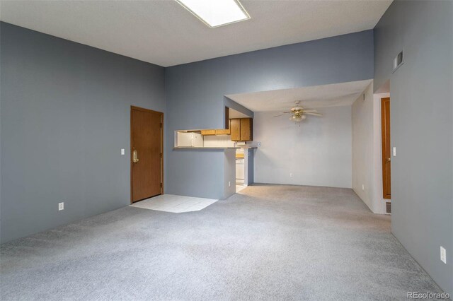 unfurnished living room featuring light carpet and ceiling fan