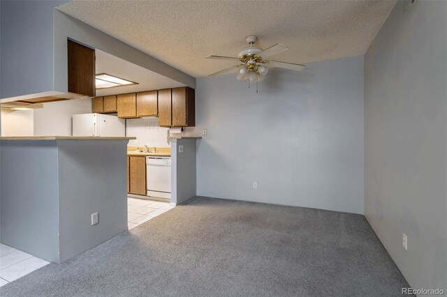 kitchen with a textured ceiling, light colored carpet, ceiling fan, and white appliances