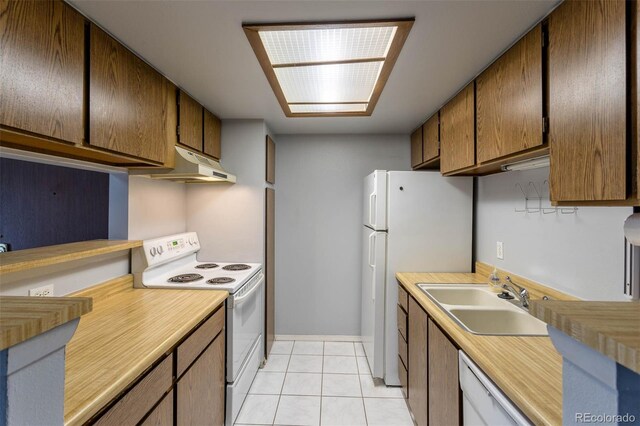 kitchen featuring sink, white appliances, and light tile patterned flooring