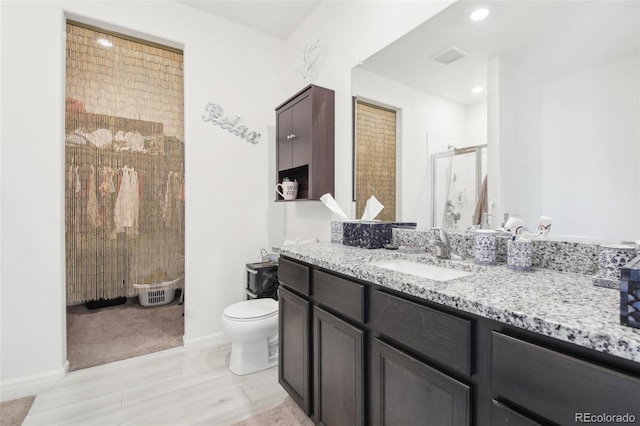 310 Quincy Rr Ave, Keenesburg, CO 80643 - bathroom with toilet, a stall shower, baseboards, wood finished floors, and vanity