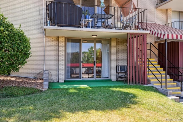 7801 W 35th Ave Unit 1, Wheat Ridge, CO 80033 - view of exterior entry with brick siding, a yard, and a balcony