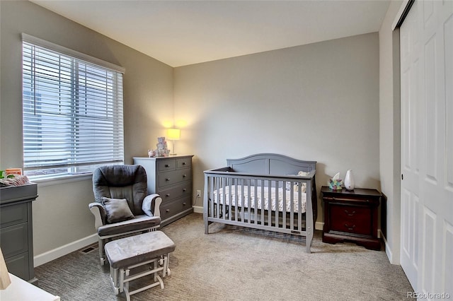 carpeted bedroom featuring a closet, baseboards, and multiple windows