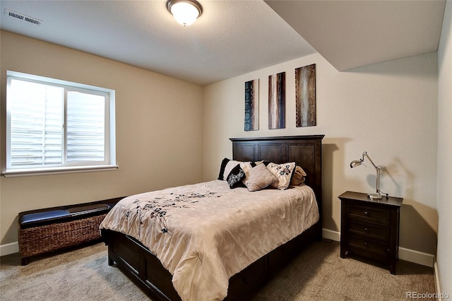 bedroom with baseboards, visible vents, and light carpet