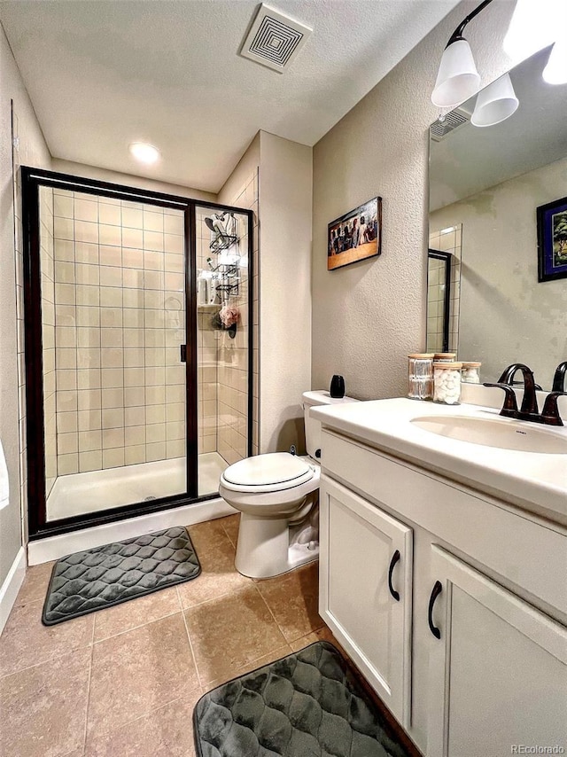 bathroom with vanity, toilet, tile patterned floors, a shower stall, and visible vents
