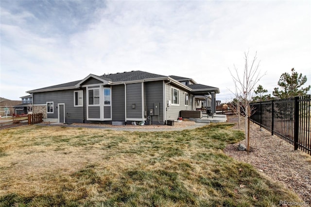 view of side of home with a fenced backyard and a lawn