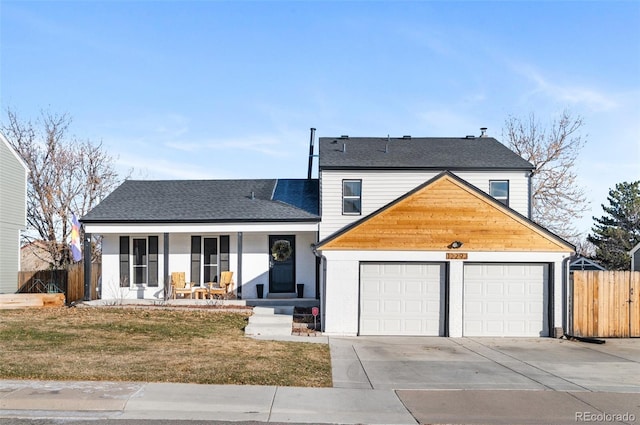 view of front of property featuring a front lawn, a garage, and a porch