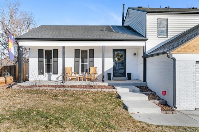 rear view of house with covered porch and a yard