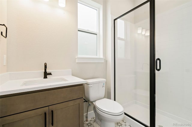 bathroom with vanity, toilet, and a shower with shower door