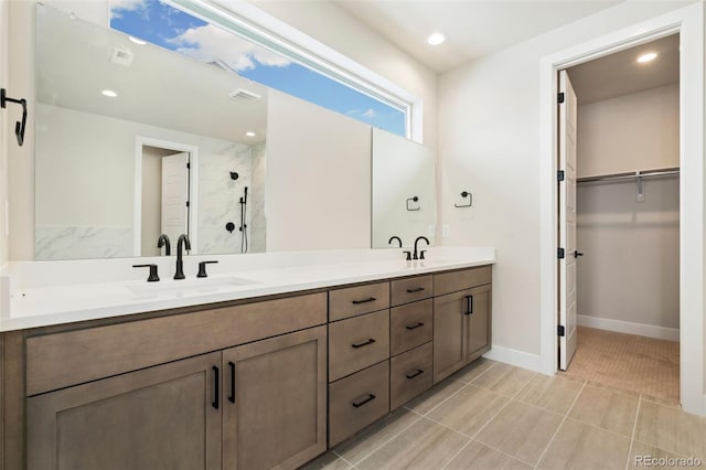 bathroom with vanity and a tile shower