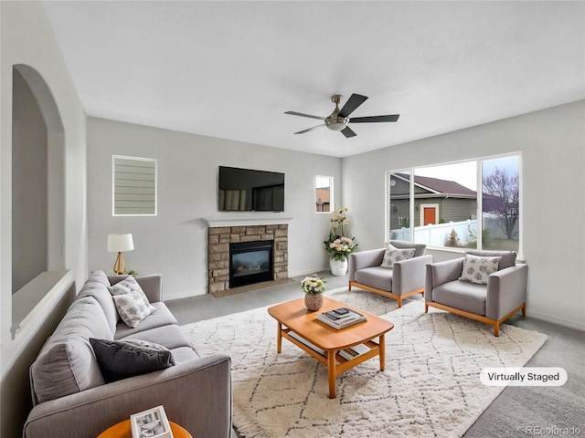 living room with baseboards, arched walkways, ceiling fan, and a wealth of natural light