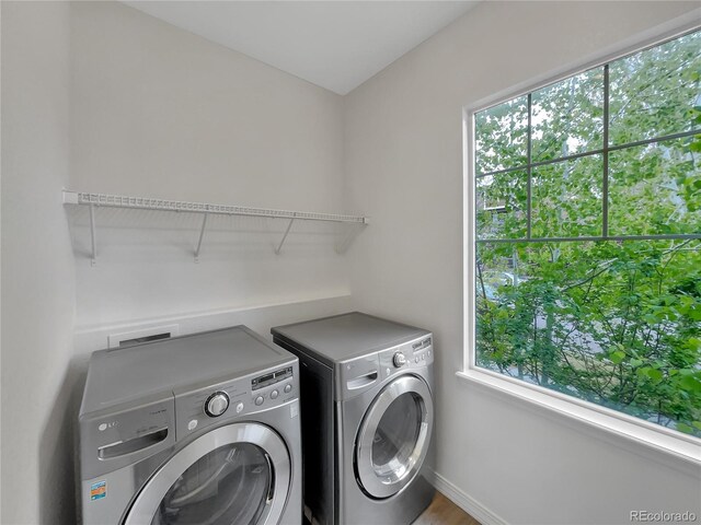 washroom featuring laundry area, baseboards, independent washer and dryer, and a healthy amount of sunlight