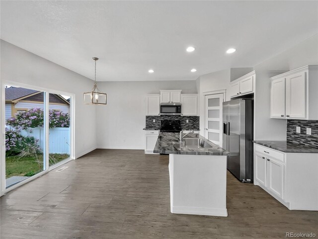 kitchen with a sink, tasteful backsplash, stainless steel appliances, and white cabinets
