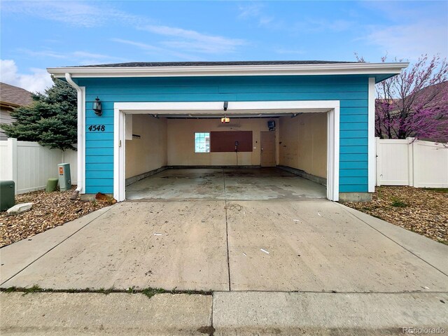 garage with fence and driveway