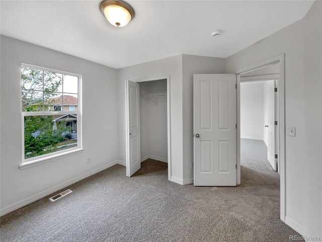 unfurnished bedroom featuring visible vents, carpet flooring, baseboards, and a closet