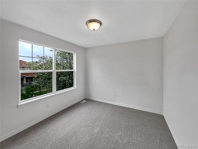 unfurnished room with baseboards and carpet floors