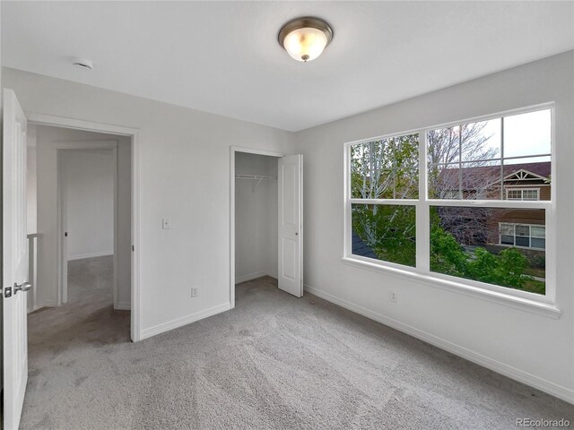 unfurnished bedroom with baseboards, carpet, and a closet