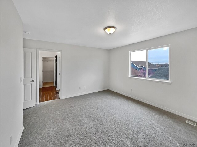 spare room with visible vents, carpet, and baseboards