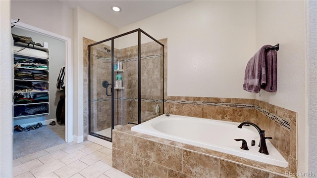6945 Fargo Trl, Littleton, CO 80125 - full bathroom featuring a bath, a stall shower, a walk in closet, and tile patterned floors