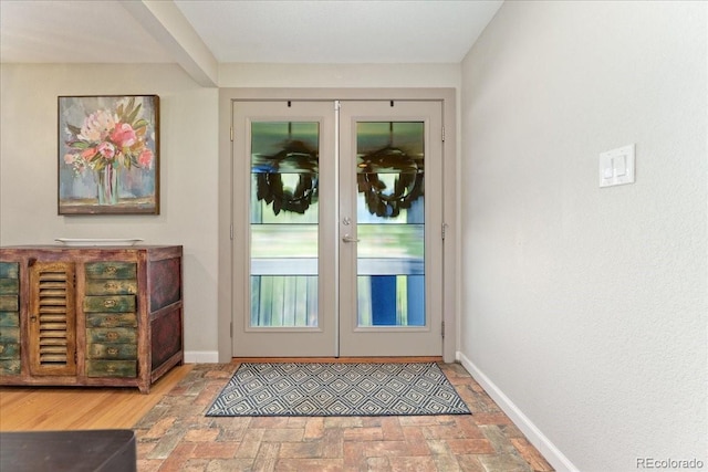 doorway to outside with brick floor, french doors, and baseboards