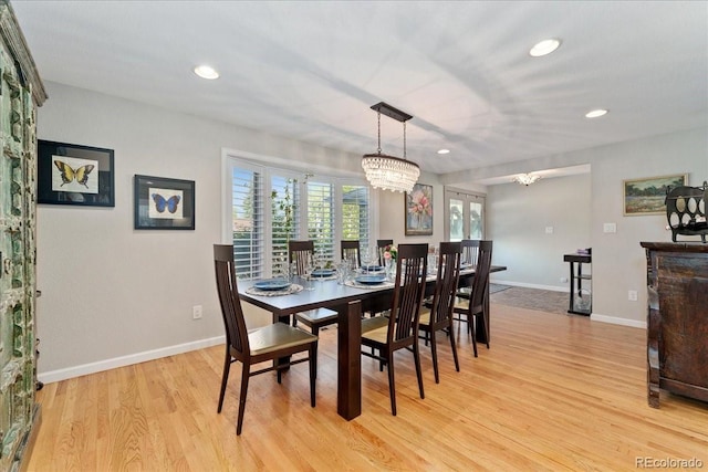 dining room featuring baseboards, recessed lighting, light wood-type flooring, and a notable chandelier