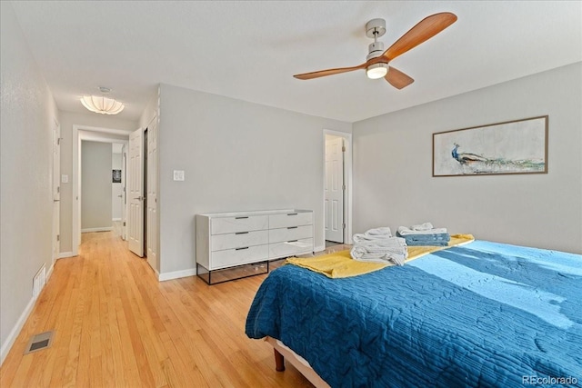 bedroom featuring light wood-type flooring, baseboards, visible vents, and a ceiling fan