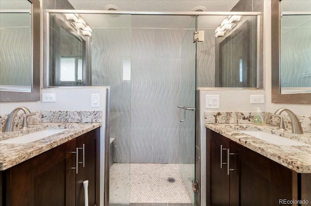 bathroom featuring two vanities, a sink, and a shower stall