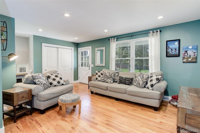 living area with recessed lighting, baseboards, and light wood-type flooring