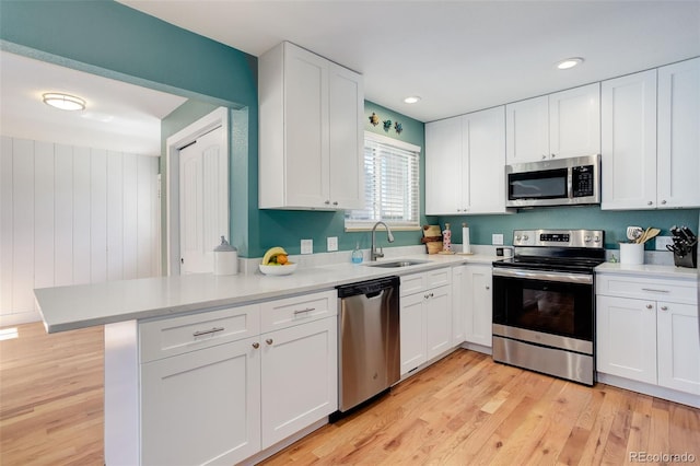 kitchen with a sink, white cabinets, and stainless steel appliances