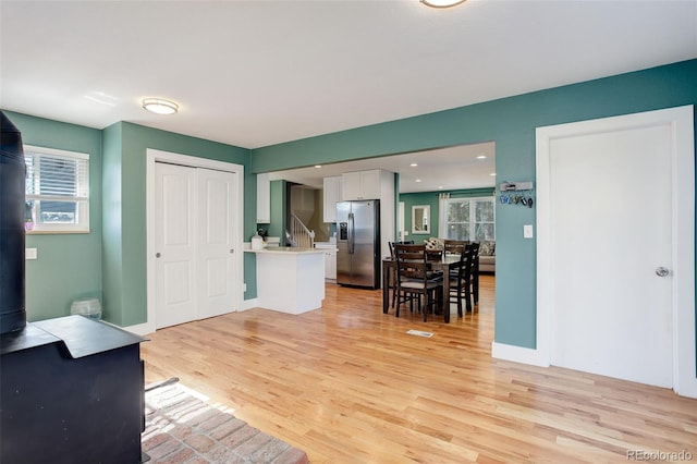 foyer featuring stairs, visible vents, a healthy amount of sunlight, and light wood-style flooring