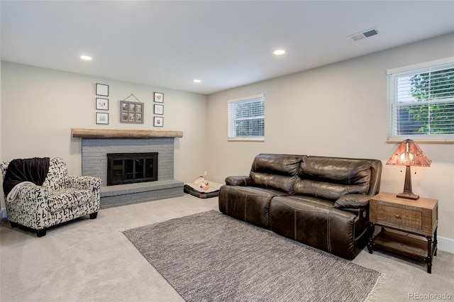 carpeted living room with visible vents, recessed lighting, and a brick fireplace