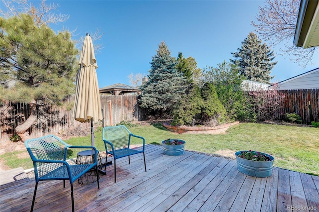 wooden terrace with a fenced backyard and a yard