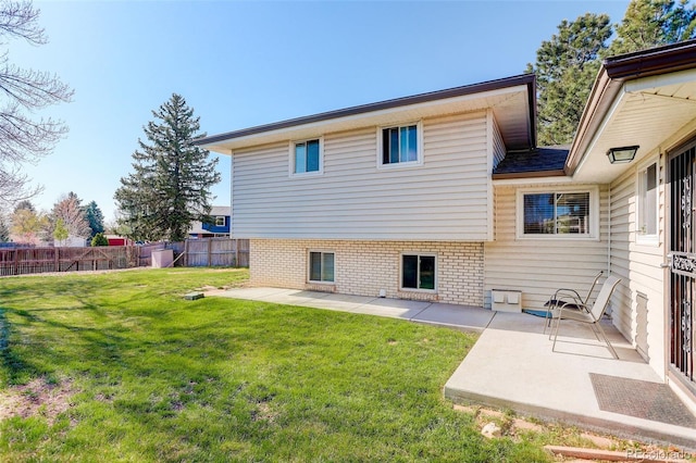 rear view of property featuring a fenced backyard, a patio area, and a yard