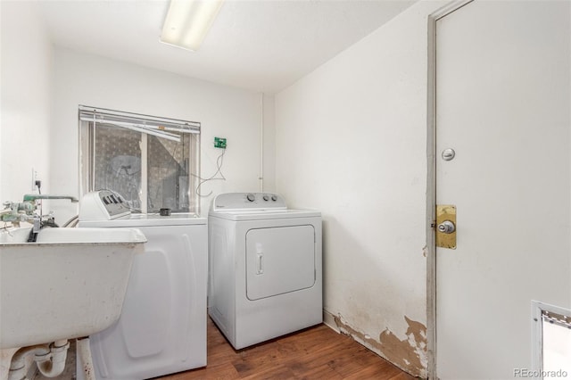 washroom with laundry area, independent washer and dryer, a sink, and wood finished floors