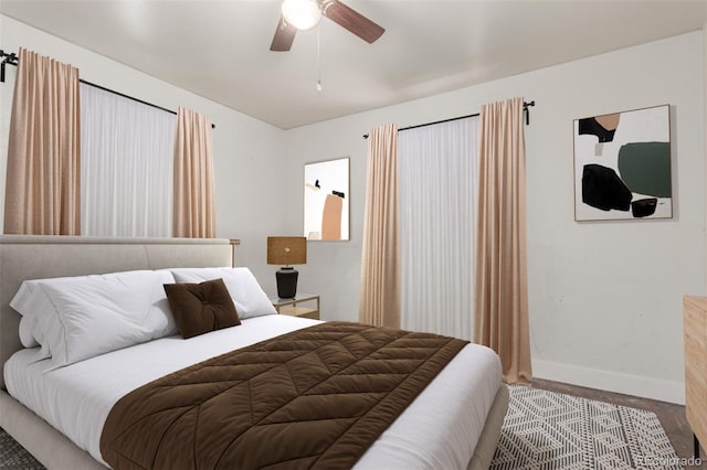 bedroom featuring ceiling fan, baseboards, and wood finished floors