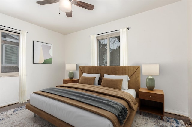 bedroom featuring ceiling fan, wood finished floors, and baseboards