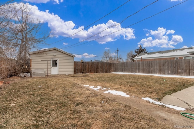 view of yard featuring an outbuilding, a storage shed, and a fenced backyard