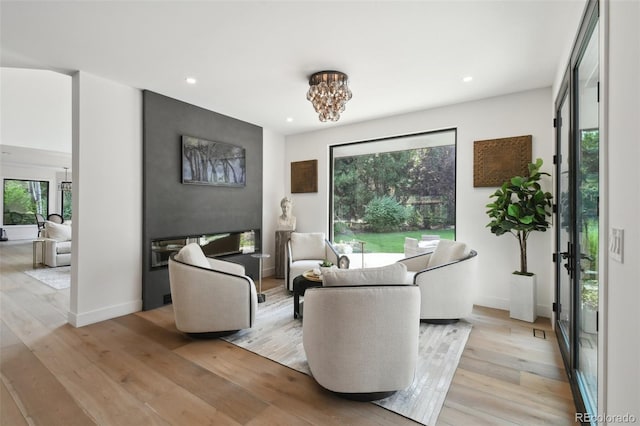 living room with a notable chandelier and light hardwood / wood-style flooring